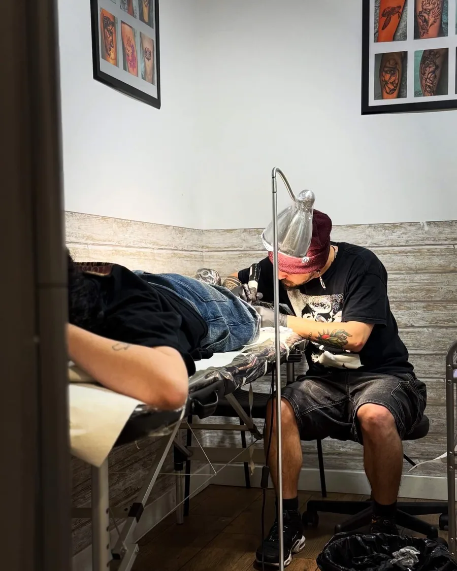 Alumno tatuando a un modelo en una cabina de la escuela ESAP de Madrid Alumno tatuando a un modelo en una cabina de la escuela ESAP de Madrid