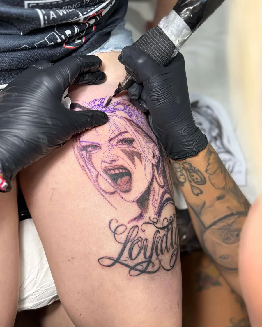 Alumno tatuando un retrato en una pierna durante las prácticas de la escuela ESAP de Madrid