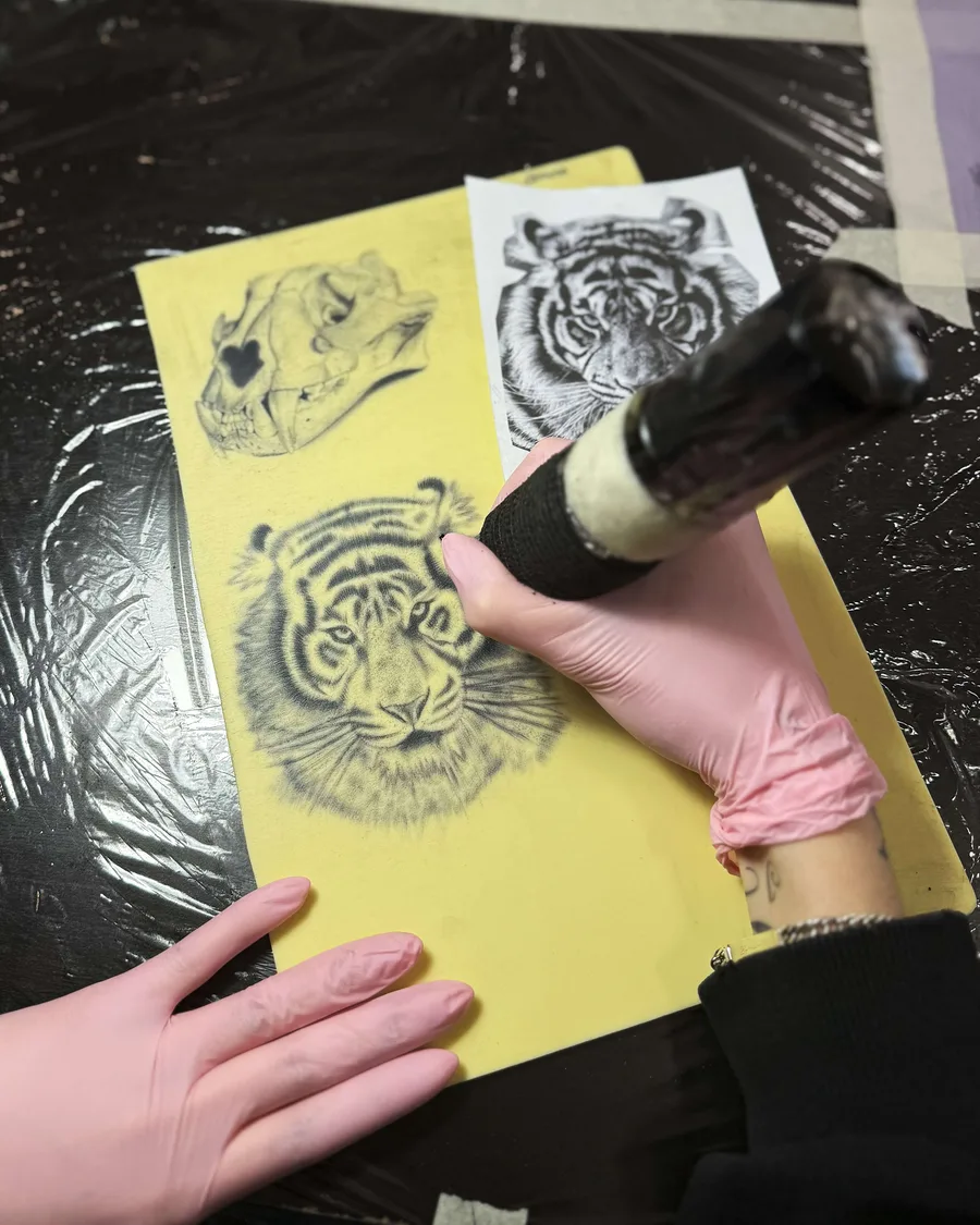 Alumno tatuando un tigre sobre piel sintética en la escuela ESAP de Madrid Alumno tatuando un tigre sobre piel sintética en la escuela ESAP de Madrid