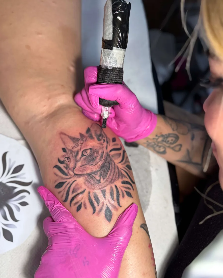 Alumna tatuando un felino en una pierna en la escuela ESAP de Madrid