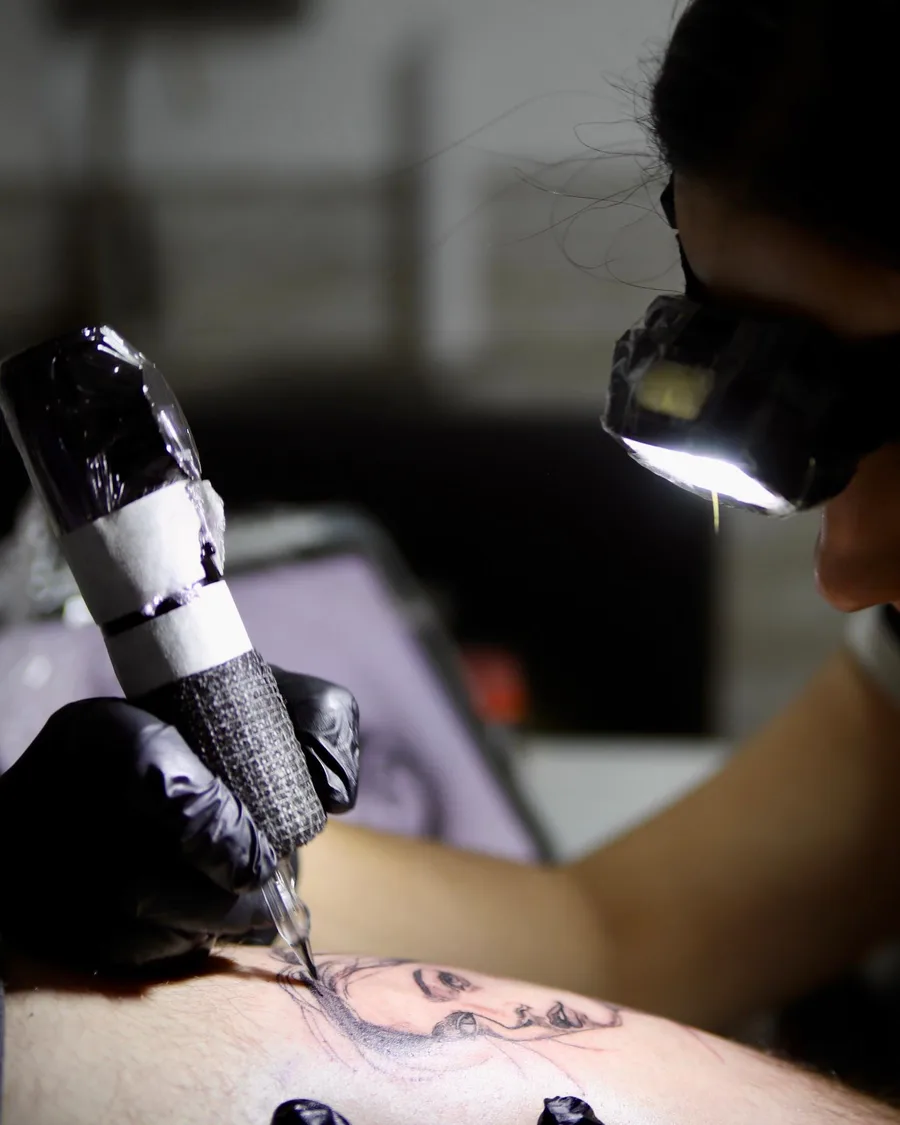 Alumno practicando el tatuaje sobre piel sintética con la máquina en la escuela ESAP de Madrid Alumno practicando el tatuaje sobre piel sintética con la máquina en la escuela ESAP de Madrid