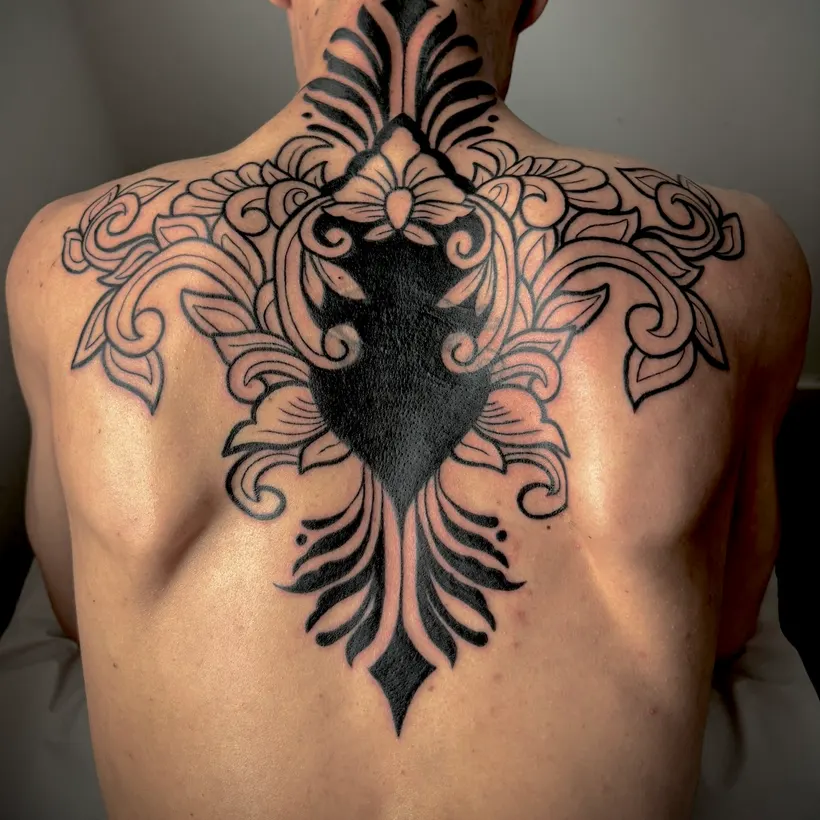 Tatuaje ornamental barroco en la espalda alta y la nuca, hecho en ESAP Madrid