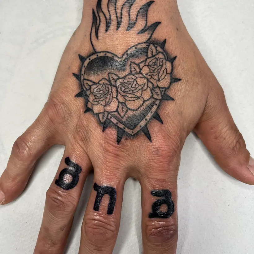 Tatuaje tradicional de sagrado corazón con rosas en el dorso de la mano, hecho en ESAP Madrid Tatuaje tradicional de sagrado corazón con rosas en el dorso de la mano, hecho en ESAP Madrid