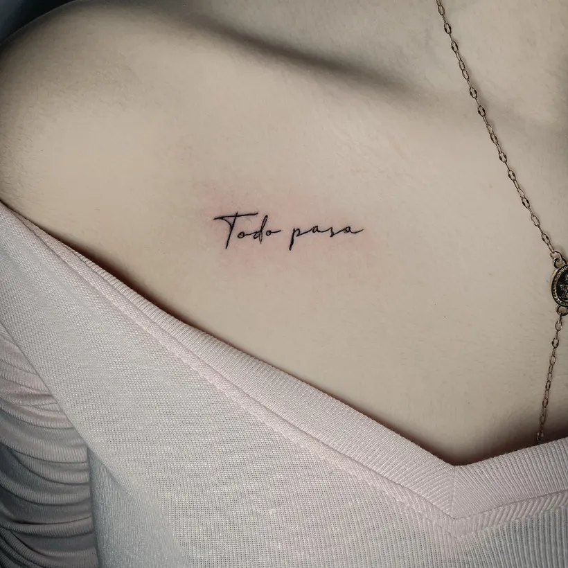 Tatuaje de lettering fino «Todo pasa» en la clavícula, hecho en ESAP Madrid